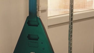 Fabrikada asılı duran üçgen elektro gitar. Yüksek kalite 4k görüntü