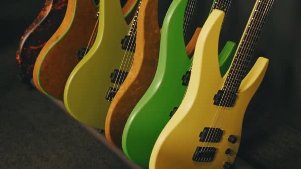 Барвисті Електричні Гітари Спираються Стіну Студії Високоякісні Кадри — стокове відео