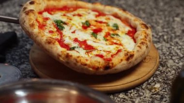Tahtaya yeni yapılmış pizza koyarak, arka planda aşçı olarak. Yüksek kalite 4k görüntü