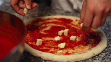 Pizzaya peynir ekleyen eller, yakın çekim görüntüsü. Yüksek kalite 4k görüntü