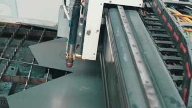 Metal levhayı kesen lazer makinesi. CNC 'yi otomatik olarak keserek lazerden kıvılcımlar saçılıyor. Yüksek kalite 4k görüntü