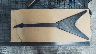 top down view of a newly made carbon fiber guitar in the MDF board mold. High quality photo