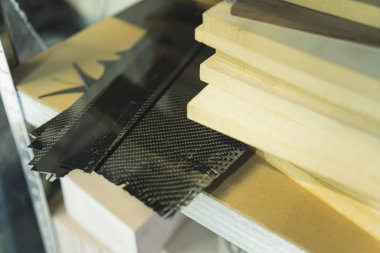 Masanın üzerinde tahta parçaları olan karbon fiber parçalarının yakın plan çekimi modern karbon fiber gitar yapıyor. Yüksek kalite fotoğraf