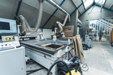 view of the modern machines at the factory, industrial concept, milling machine and MDF board molds for guitars. High quality photo