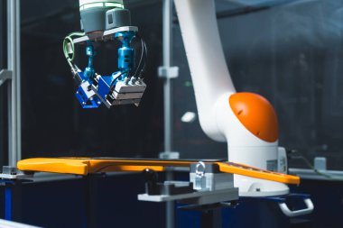 Robot kolun yakın çekimi sarı gitarı, müzik aletini ve modern tekniği, endüstriyel robotu ve fabrika denetimini kontrol ediyor. Yüksek kalite fotoğraf