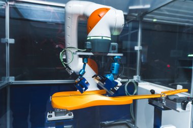 Gitarı kontrol etmek, robot kolu fabrikada sarı modern gitar üzerinde çalışmak, endüstriyel robotların fabrika teftişi. Yüksek kalite fotoğraf