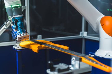 Sarı gitarın yakın çekimi ve robot kolu boyayı kontrol ediyor. Otomatik modern kalite kontrol yöntemi. Yüksek kalite fotoğraf