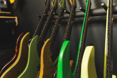 closeup of colorful electric guitars near a wall in the music studio, modern instruments, rehearsal studio. High quality photo clipart