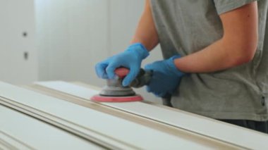 Marangoz marangozluk veya marangozluk atölyesinde zımpara kağıdı ile ahşap öğütüyor. Marangozlukta çalışan elektrikli zımpara makinesi. Yüksek kalite 4k görüntü