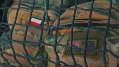 15.08.2023. Varşova, Polonya. Polonyalı ve İngiliz bayrak çıkartmaları askeri sırt çantalarına yapıştırılmış, askeri kavram. Yüksek kalite 4k görüntü