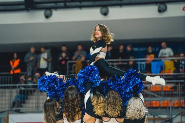 Modern Spor Arenası 'nda coşkulu bir ruhla ponpon kızlar dans gösterisi yapıyor. Yüksek kalite fotoğraf