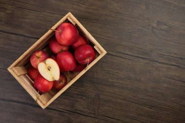 Küçük kırmızı sonbahar çileği biçimli elma dilimi tahta sandık içinde köy ahşap arka planında.  