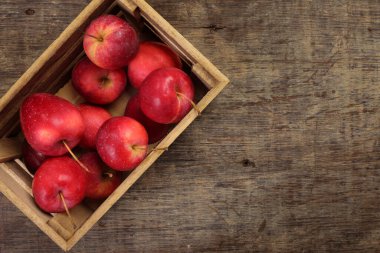 Küçük kırmızı sonbahar çileği biçimli elma dilimi tahta sandık içinde köy ahşap arka planında.  