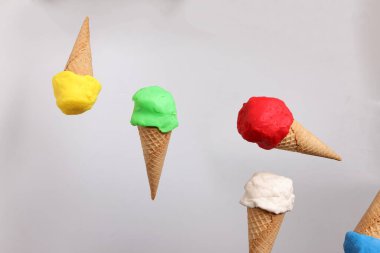 Sahte modelleme kil çok renkli dondurma waffle bisküvi küvi damla beyaz zemin üzerine düşer 