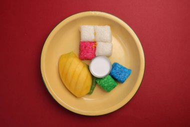 Tayland tatlısı tatlı çöl kırmızı mavi mango beyaz mango yapışkan pirinç hindistan cevizi kremalı süt teneke metal kaşık tahta arka plan kırmızı 