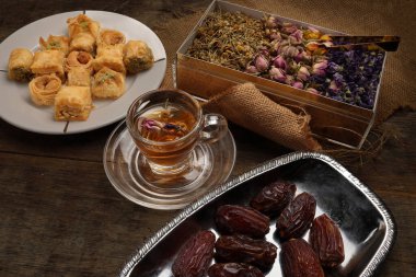 Doldurulmuş hamur işi Baklava Ortadoğu tatlı tatlı tatlı olgun meyveli tatlı meyve kuru çiçek goncası kelebek papatya çiçeği çiçekli çay şeffaf cam fincan fincanı kırsal ahşap arka planda 