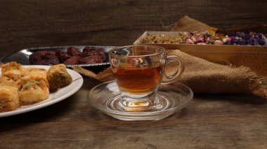 Doldurulmuş hamur işi Baklava Ortadoğu tatlı tatlı tatlı olgun meyveli tatlı meyve kuru çiçek goncası kelebek papatya çiçeği çiçekli çay şeffaf cam fincan fincanı kırsal ahşap arka planda 