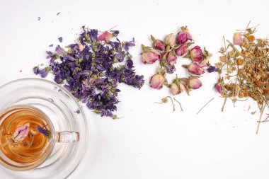 Kuru çiçek çayı kelebek bezelye çiçeği şeffaf seramik cam çay fincanı beyaz zemin üzerinde 