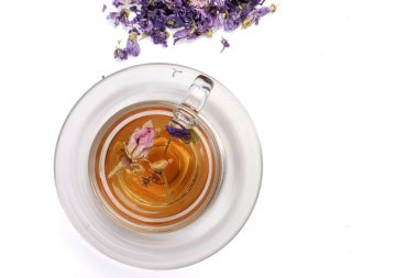 Kuru çiçek çayı kelebek bezelye çiçeği şeffaf seramik cam çay fincanı beyaz zemin üzerinde 