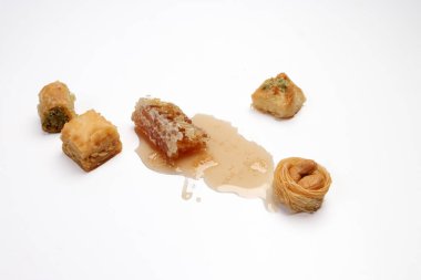 Doldurulmuş hamur işi Baklava tatlı tatlı tatlı meyve suyu bal doğal jeomatik balmumu bal peteği çiçekli gül goncası kelebek papatya çiçeği çiçeği çayı şeffaf cam bardak fincanda beyaz zemin üzerinde çay 