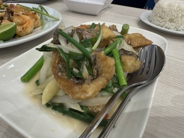 Kızarmış deniz kabuğu filetosu ve taze soğan. 