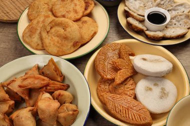 Bengali tatlı tuzlu çerezler çeşitli doldurulmuş gözleme chitoi bhapa nakshi pakkon pitha singara samosa dal aloo puri kızartılmış pirinç Cheera karışımı sade metal kaplama üzerinde rustik arka plan üzerinde 