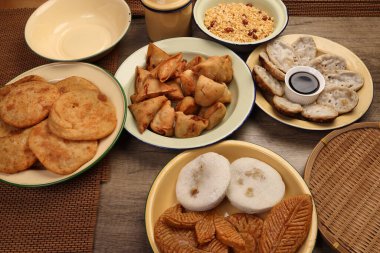 Bengali tatlı tuzlu çerezler çeşitli doldurulmuş gözleme chitoi bhapa nakshi pakkon pitha singara samosa dal aloo puri kızartılmış pirinç Cheera karışımı sade metal kaplama üzerinde rustik arka plan üzerinde 