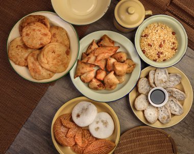 Bengali tatlı tuzlu çerezler çeşitli doldurulmuş gözleme chitoi bhapa nakshi pakkon pitha singara samosa dal aloo puri kızartılmış pirinç Cheera karışımı sade metal kaplama üzerinde rustik arka plan üzerinde 