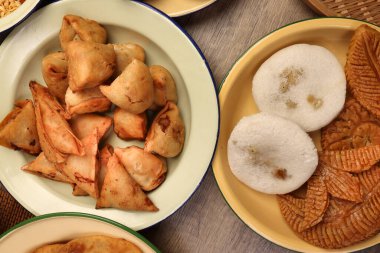 Bengali tatlı tuzlu çerezler çeşitli doldurulmuş gözleme chitoi bhapa nakshi pakkon pitha singara samosa dal aloo puri kızartılmış pirinç Cheera karışımı sade metal kaplama üzerinde rustik arka plan üzerinde 
