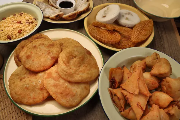 Bengali tatlı tuzlu çerezler çeşitli doldurulmuş gözleme chitoi bhapa nakshi pakkon pitha singara samosa dal aloo puri kızartılmış pirinç Cheera karışımı sade metal kaplama üzerinde rustik arka plan üzerinde 
