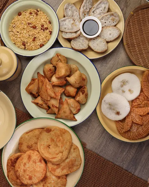 Bengali tatlı tuzlu çerezler çeşitli doldurulmuş gözleme chitoi bhapa nakshi pakkon pitha singara samosa dal aloo puri kızartılmış pirinç Cheera karışımı sade metal kaplama üzerinde rustik arka plan üzerinde 