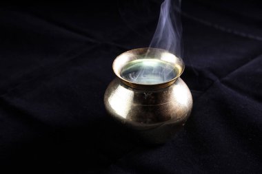 Pirinç bakır metal stili kazan dumanı içinde yanan duman yükselen sis hareket ederek siyah arkaplanda dönüyor 