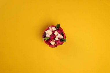 Güzel Mangosteen mango ejderhası küp meyve salatası içinde ejderha meyve kabı sarı arka planda yeşil muz yaprağı 