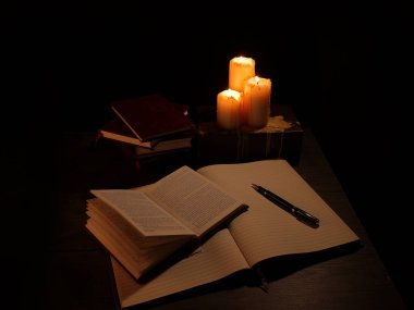 Kitabın fotokopi kaleminde yanan üç mum siyah arkaplanı çeviriyor. 