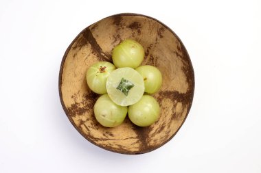 Amloki Indian gooseberry herbal medicinal healthy fruit on white background in coconut shell bowl  clipart