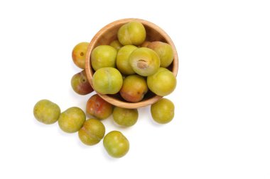 Olgun, küçük, tatlı erik yeşil kestane rengi beyaz arka planda 