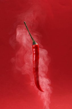 Uçan kırmızı kuşlar, kırmızı arka planda kırmızı biber, buhar buharı, dönen sis, dönen girdap. 