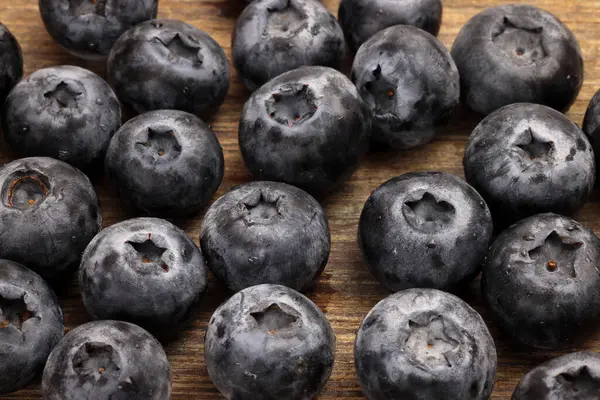 Taze olgun yaban mersinleri ahşap arka planda mavi dut 
