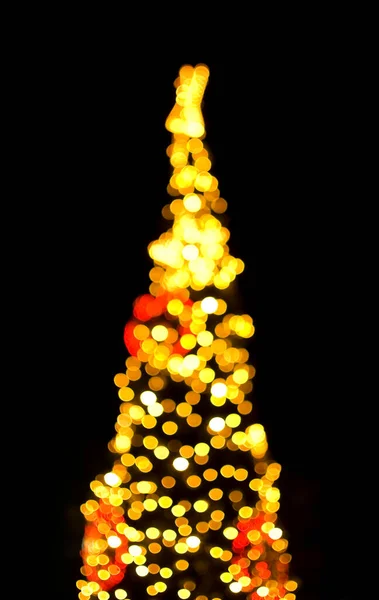 Illuminated defocused Christmas tree in the street.