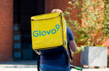 Poznan, Polonya - 14 Ağustos 2023: Glovo gıda dağıtım kuryesi.