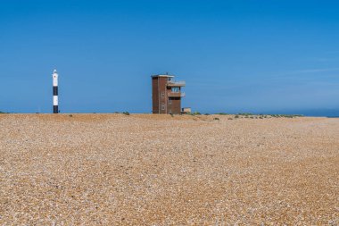 Dungeness, Kent, İngiltere 'de Eski Cankurtaran İstasyonu ve Yeni Deniz Feneri' nin olduğu plaj.