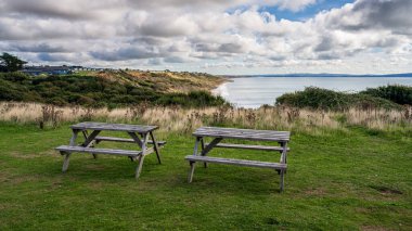 Highcliffe, Dorset, İngiltere ve İngiltere 'deki tepeler ve Naish Beach manzaralı piknik bankları.