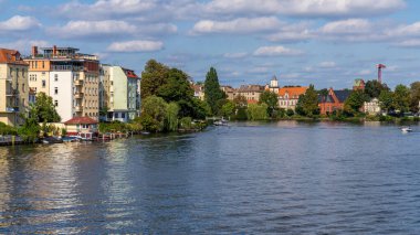 Berlin-Koepenick, Almanya - 14 Eylül 2021: Dahme Nehri 'ndeki Lange Bruecke' den ve nehir kenarındaki evlerden görüntü