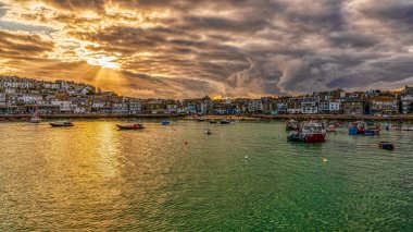 St. Ives, Cornwall, İngiltere - 30 Mayıs 2022: Limanda akşam güneşi ve bulutlar