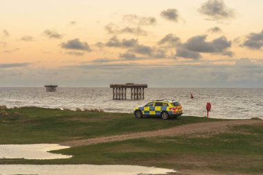 Sizewell, Suffolk, İngiltere - 16 Kasım 2022: Sahilde bir polis arabası ve arka planda açık deniz platformları