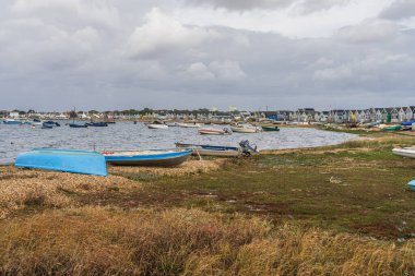 Mudeford Sandbank, Dorset, İngiltere - 27 Eylül 2022: Webb Körfezi 'ndeki sahil kulübelerinin ve teknelerin görüntüsü