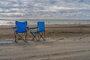 West Wittering, West Sussex, İngiltere - Ekim 03, 2022: Sahilde iki kamp sandalyesi