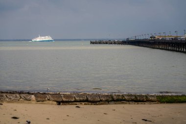 Ryde, Isle of Wight, England, UK - April 21, 2023: A ferry on the way to Portsmouth, with the pier on the right clipart