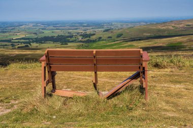 A broken bench with a view from the Hartside Pass between Alston and Penrith, Cumbria, England, UK clipart