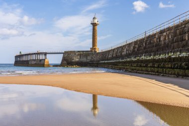 Whitby, North Yorkshire, İngiltere - 21 Haziran 2023: The Whitby Harbour West Lighthouse ve West Pier, sahilden görüldü.